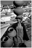 Carrying many jars. Mandalay, Myanmar (black and white)