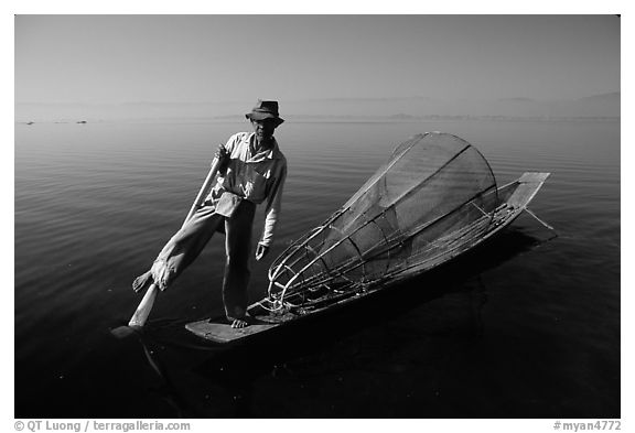 Intha fisherman on duggout with net. Inle Lake, Myanmar (black and white)