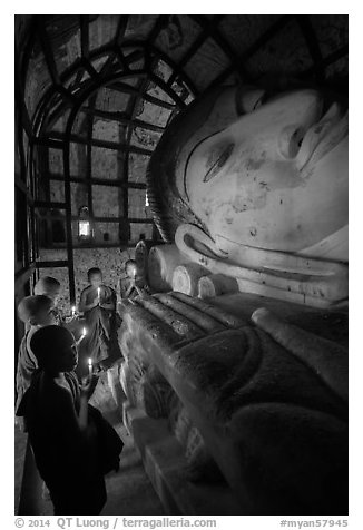 Novices praying in front of Shinbinthalyaung reclining Budddha head. Bagan, Myanmar (black and white)