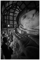 Novices praying in front of Shinbinthalyaung reclining Budddha head. Bagan, Myanmar ( black and white)