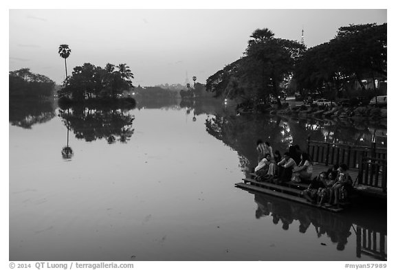 Families on shore of Kandawkyi Lake at sunset. Yangon, Myanmar (black and white)