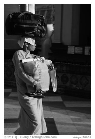 Nun carrying lots of luggage, Shwedagon Pagoda. Yangon, Myanmar (black and white)