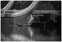 Man rowing boat next to Karawek barge. Yangon, Myanmar ( black and white)