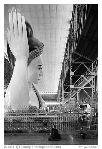 Monk and reclining Buddha statue housed in large metal shed, Kyauk Htat Gyi Pagoda. Yangon, Myanmar (black and white)