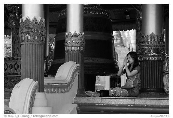 Woman praying next to bell, Shwedagon Pagoda. Yangon, Myanmar (black and white)