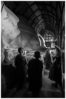 Novices standing with candles next to Shin Bin Thal Yaung reclining Budddha. Bagan, Myanmar ( black and white)