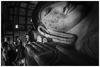 Young monks with candles worship Shin Bin Thal Yaung reclining Budddha. Bagan, Myanmar ( black and white)