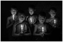 Young buddhist monks holding candles with eyes closed. Bagan, Myanmar ( black and white)