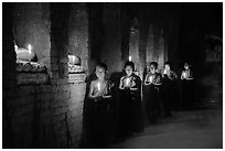 Buddhist novices in temple illuminated with candles. Bagan, Myanmar ( black and white)