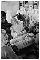 Women polishing buddha statue. Mandalay, Myanmar ( black and white)