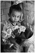 Child carrying offering bowl and flowers for novitiation ceremony, Mahamuni Pagoda. Mandalay, Myanmar ( black and white)