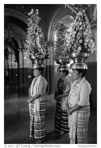 Women carry elaborate flower offerings on their head, Mahamuni Pagoda. Mandalay, Myanmar (black and white)