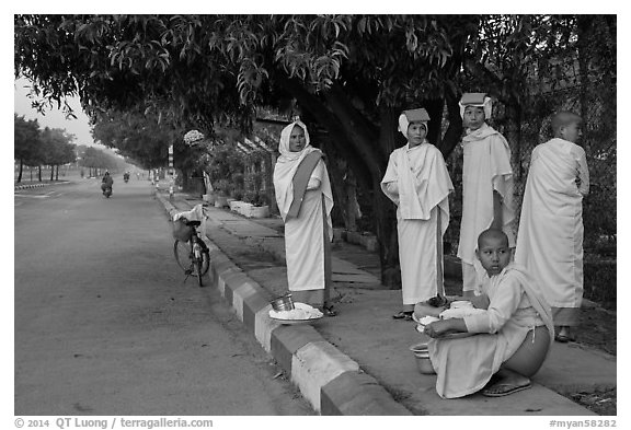 Nuns waiting for ride on sidewalk. Mandalay, Myanmar (black and white)