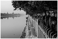 Monks walking in line in alm bowls near Mandalay Fort moat. Mandalay, Myanmar ( black and white)