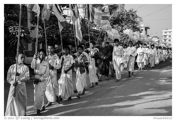 Children carry Buddhist flags ahead of alms procession. Mandalay, Myanmar (black and white)