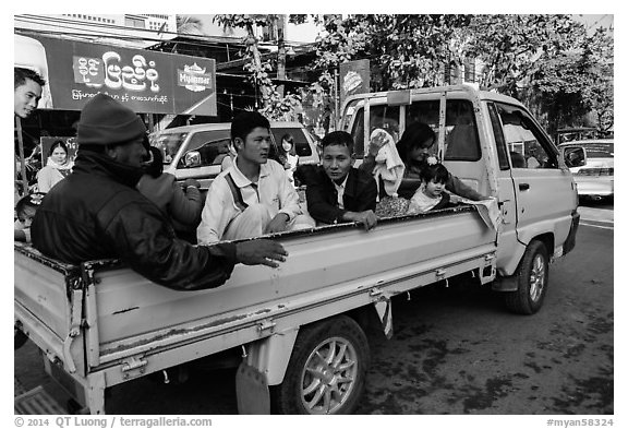 Families riding on back of pick-up truck. Mandalay, Myanmar (black and white)
