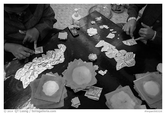 Gossamer-thin pieces of gold cut in squares, gold leaf workshop. Mandalay, Myanmar (black and white)