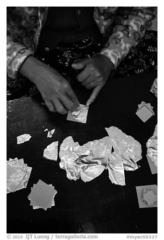 Close-up of hands separating gold leaves. Mandalay, Myanmar (black and white)