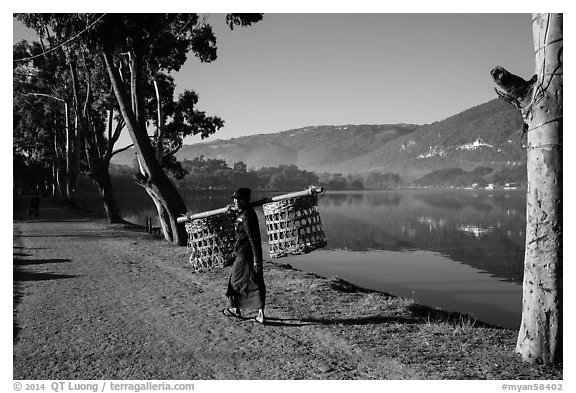 Man carrying baskets on road near Pone Tanoke Lake. Pindaya, Myanmar (black and white)