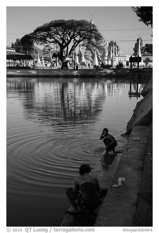 Women washing and doing laundry in lake with pagoda in background. Pindaya, Myanmar (black and white)
