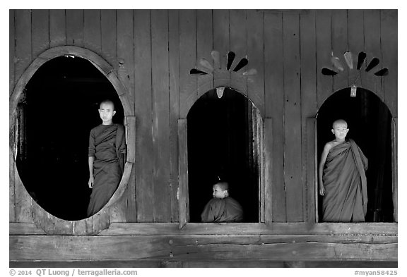 Buddhist monks looking through windows of Shweyanpyay Monastery, Nyaung Shwe. Inle Lake, Myanmar (black and white)