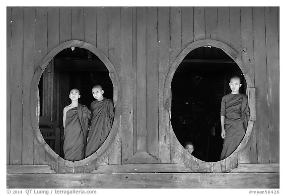 Monks standing in oval windows, Shweyanpyay Monastery, Nyaung Shwe. Inle Lake, Myanmar (black and white)