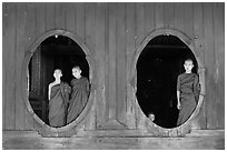 Monks standing in oval windows, Shweyanpyay Monastery, Nyaung Shwe. Inle Lake, Myanmar ( black and white)
