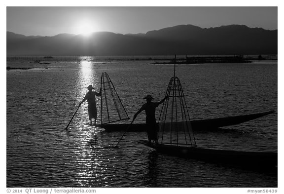 Intha fishermen on long flat-bottomed boats at sunset. Inle Lake, Myanmar (black and white)