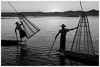 Intha fishermen lifting traditional conical net at sunset. Inle Lake, Myanmar ( black and white)