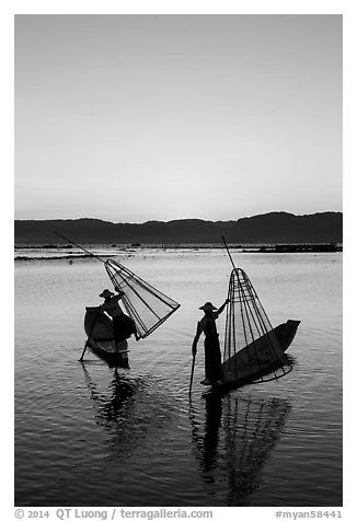 Intha fishermen lifting conical basket net at sunset. Inle Lake, Myanmar (black and white)