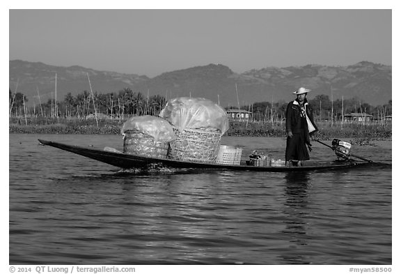 Man transporting baskets on boat. Inle Lake, Myanmar (black and white)