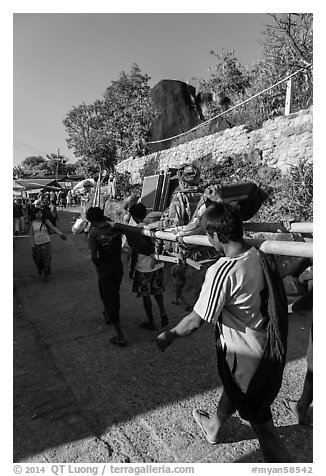 Vistor carried by porters on sedan chair,. Kyaiktiyo, Myanmar (black and white)