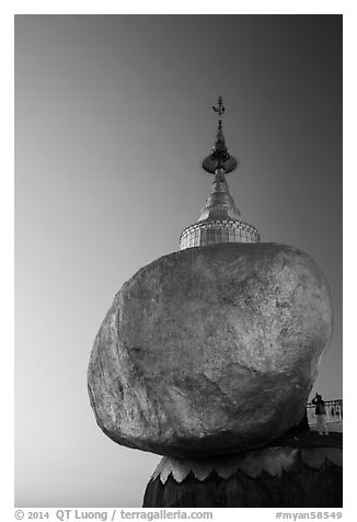 Pilgrim prays to the gleaming Golden Rock at sunset. Kyaiktiyo, Myanmar (black and white)