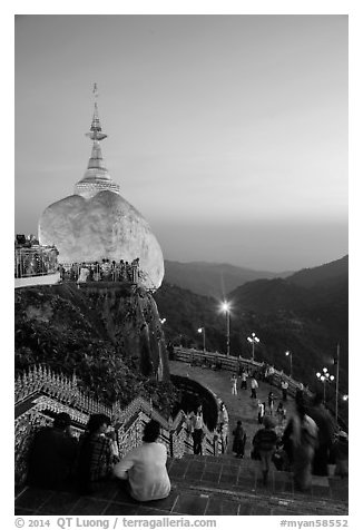 Pilgrims look at the Golden Rock from lower platform at sunset. Kyaiktiyo, Myanmar (black and white)