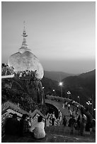 Pilgrims look at the Golden Rock from lower platform at sunset. Kyaiktiyo, Myanmar ( black and white)