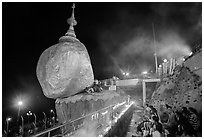 Pilgrims pray next to the Golden Rock. Kyaiktiyo, Myanmar ( black and white)