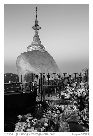 Pilgrim and food offerings behind Golden Rock at dawn. Kyaiktiyo, Myanmar (black and white)