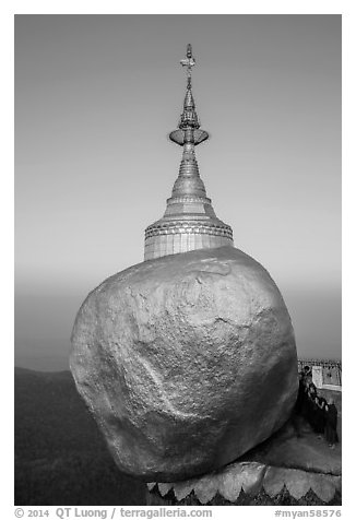 Monks standing in prayer near the Golden rock at sunrise. Kyaiktiyo, Myanmar (black and white)