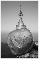 Monks standing in prayer near the Golden rock at sunrise. Kyaiktiyo, Myanmar ( black and white)