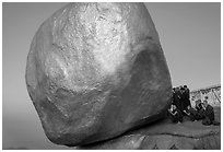 Monks praying at the Golden Rock balancing boulder. Kyaiktiyo, Myanmar ( black and white)