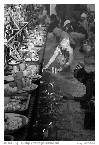 Morning food offering and pilgrims with cold weather hats. Kyaiktiyo, Myanmar (black and white)
