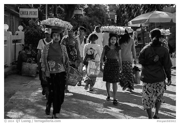 Women walk with platers of food on their heads. Kyaiktiyo, Myanmar (black and white)