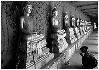 Woman worships a buddha image, Wat Arun. Bangkok, Thailand (black and white)