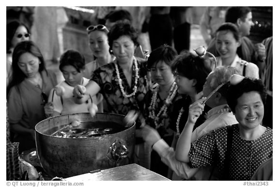 Worshippers dip lotus flowers and bring them to their heads. Bangkok, Thailand