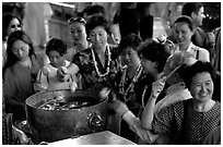 Worshippers dip lotus flowers and bring them to their heads. Bangkok, Thailand (black and white)