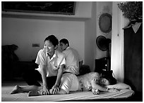 Traditional thai massage in traditional Thai medicine center of Wat Pho. Bangkok, Thailand (black and white)