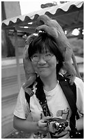 Monkeys climb on a tourist, San Phra Kan. Lopburi, Thailand ( black and white)