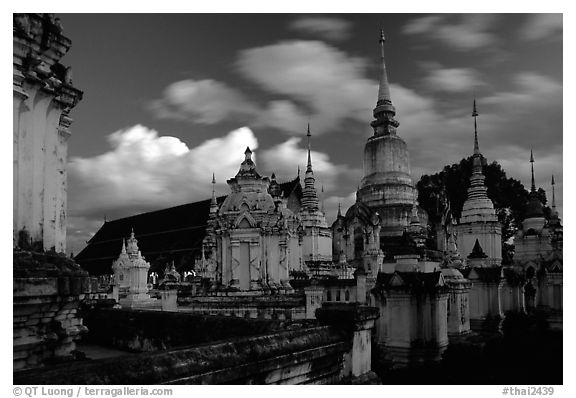 Chedis in blue light with bright clouds, Wat Suan Dok, dusk. Chiang Mai, Thailand