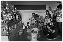 Worshippers with lotus inside Wat Saket. Bangkok, Thailand (black and white)