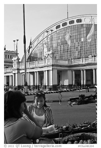 Woman buying food at stall in front of station. Bangkok, Thailand